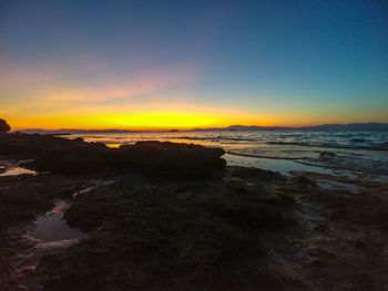 Scenic view of beach against sky during sunset