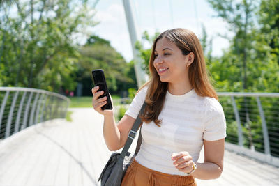 Smiling young woman using mobile phone