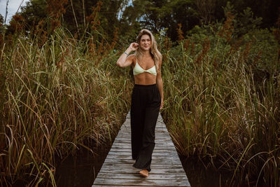 Full length of woman standing on boardwalk