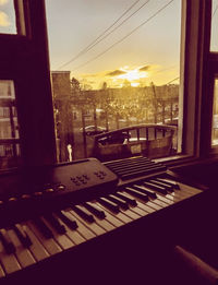 Buildings seen through glass window during sunset