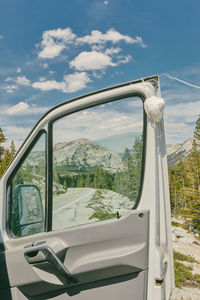 Open camper van door and mask on highway in yosemite national park.