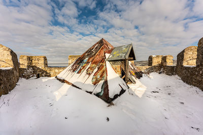 Panoramic view of old buildings on field against sky