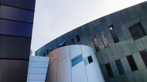 Low angle view of modern building against blue sky