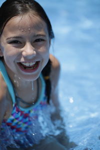 High angle view of happy girl enjoying summer in swimming pool