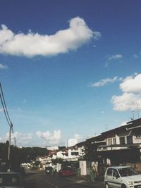 Cars on road against cloudy sky