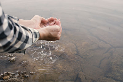 Cropped image of person holding water in cupped hands
