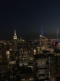 Illuminated buildings in city against sky at night