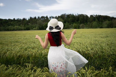 Rear view of woman standing on field