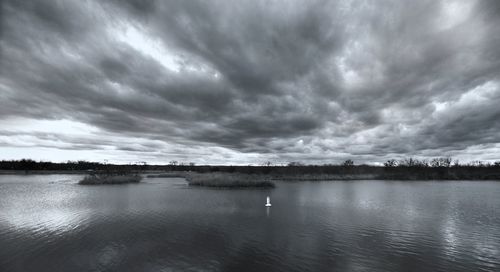 Scenic view of lake against dramatic sky