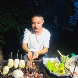 Young man preparing food on barbecue grill