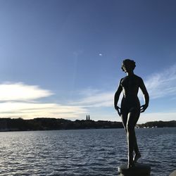 Man standing by sea against sky