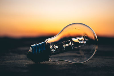 Close-up of bulb against sky during sunset