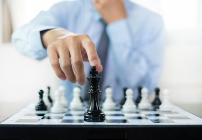 Midsection of man playing chess