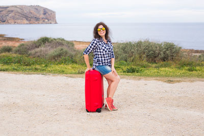 Full length portrait of young woman on land