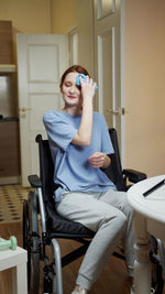 Smiling young woman sitting on wheelchair