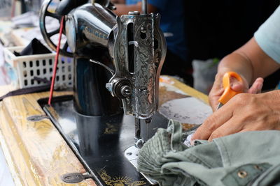 Cropped hand cutting textile on sewing machine