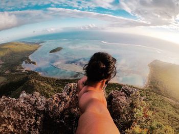 Low section of woman in sea against sky