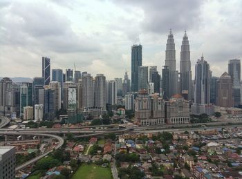 View of skyscrapers in city against cloudy sky