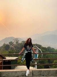 Rear view of woman standing against mountain