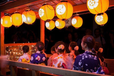 People in illuminated lanterns at night