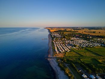 Aerial view of sea and landscape against clear sky