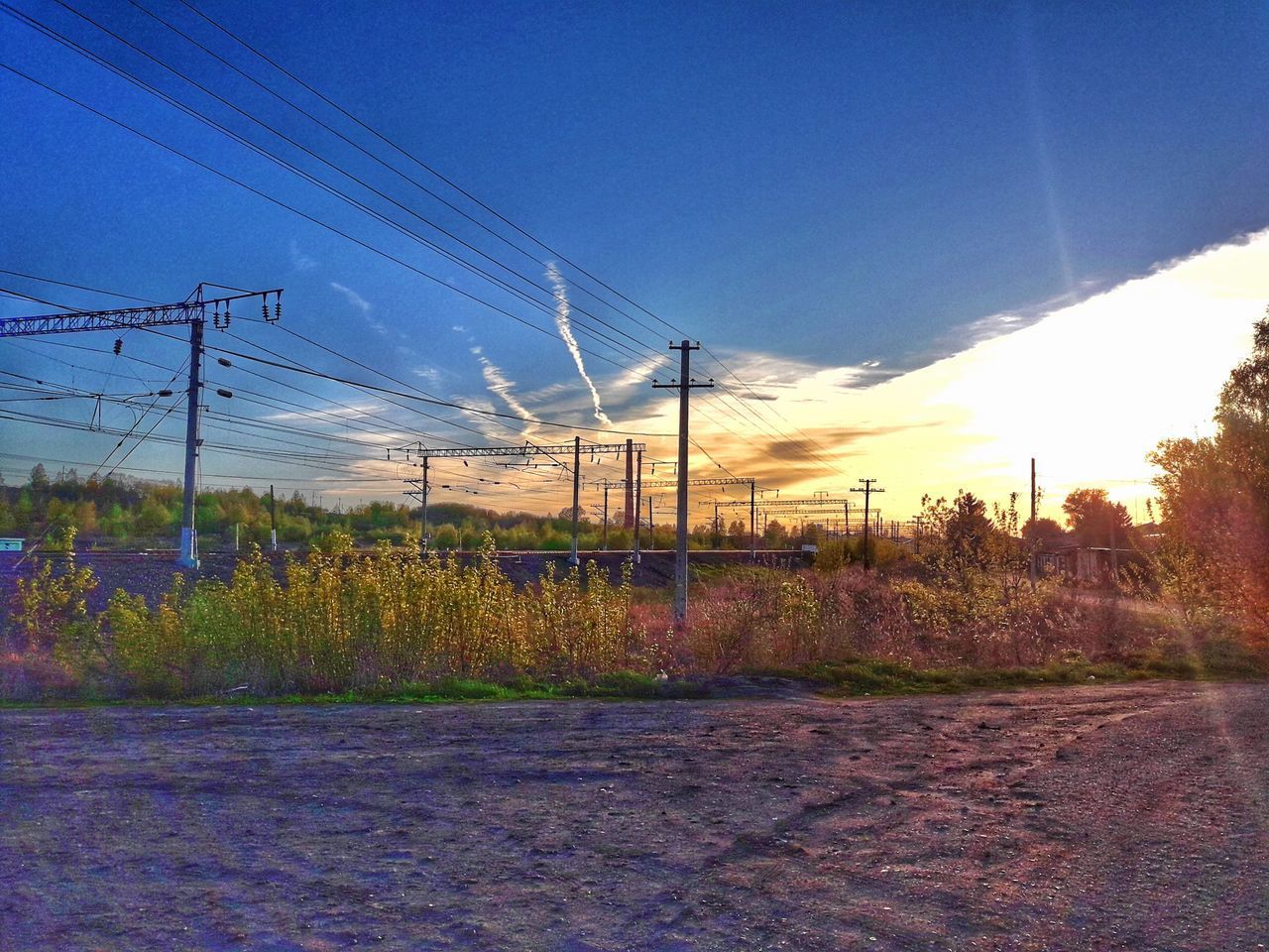 ELECTRICITY PYLON ON FIELD AGAINST SKY DURING SUNSET