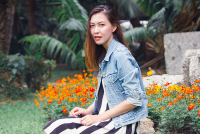 Young woman with flowers on plants