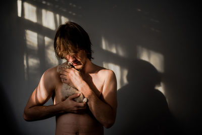 Close-up of shirtless young man holding camera