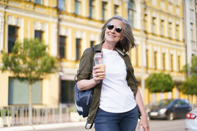 Portrait of young woman standing in city