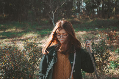 Portrait of young woman standing in forest