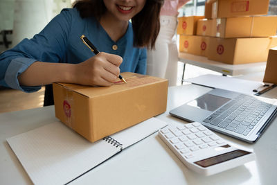 Midsection of woman using laptop on table