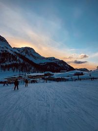 Scenic view of snow covered mountains against sky during sunset