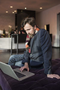 Businessman using laptop in hotel lobby