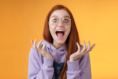 Portrait of beautiful young woman against yellow background