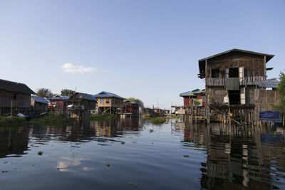 Buildings by lake against sky