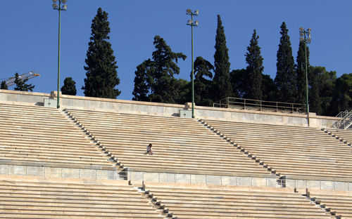 Low angle view of woman sitting on steps in stadium