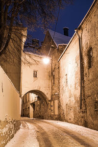 Street amidst buildings against sky at night