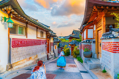 Rear view of woman walking outside temple against building