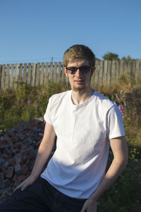 Portrait of young man wearing sunglasses standing outdoors