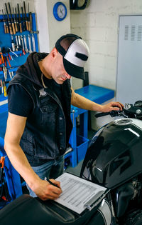 Man repairing motorcycle in garage