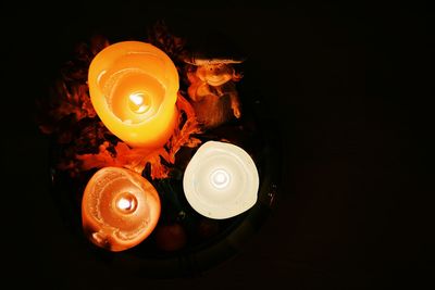 Close-up of lit candle at night