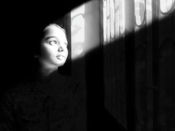 Close-up of young woman against window