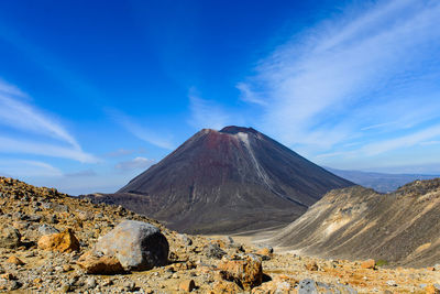 Panoramic view of volcanic mountain range against blue sky