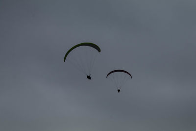 Low angle view of person paragliding against sky