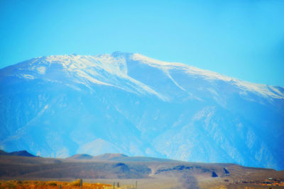 Scenic view of snowcapped mountains against blue sky