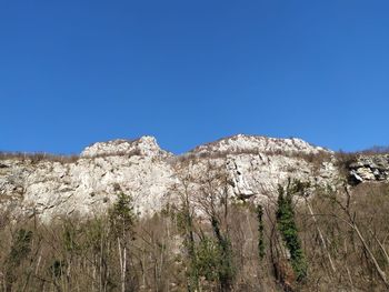 Low angle view of mountain against clear blue sky