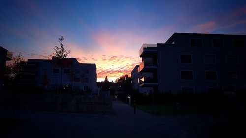 Houses against sky at sunset