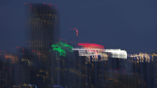 Illuminated cityscape against sky at night