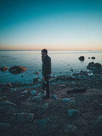 Man standing on beach against clear sky