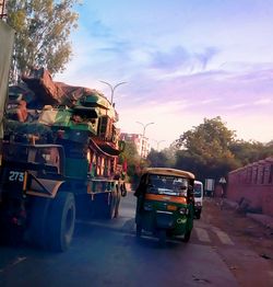 Cars on street in city against sky